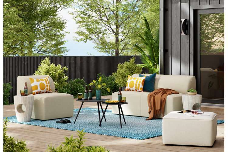 Modern patio with a blue braided outdoor rug, comfortable sectional, and stylish furniture.