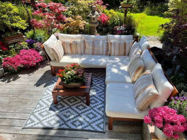 Stylish outdoor sectional sofa with striped cushions and a geometric Outdoor Rug in a vibrant garden.