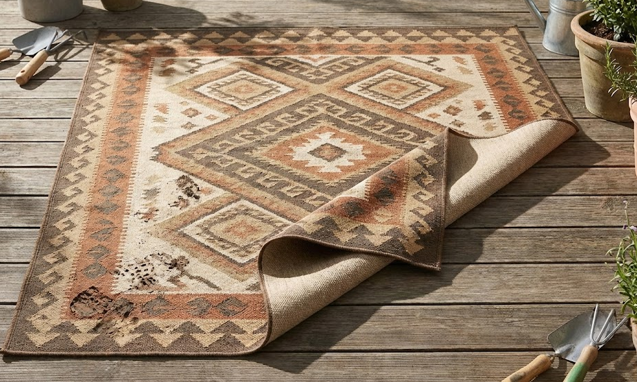 Stylish reversible outdoor rugs with a southwestern pattern on a wooden deck.