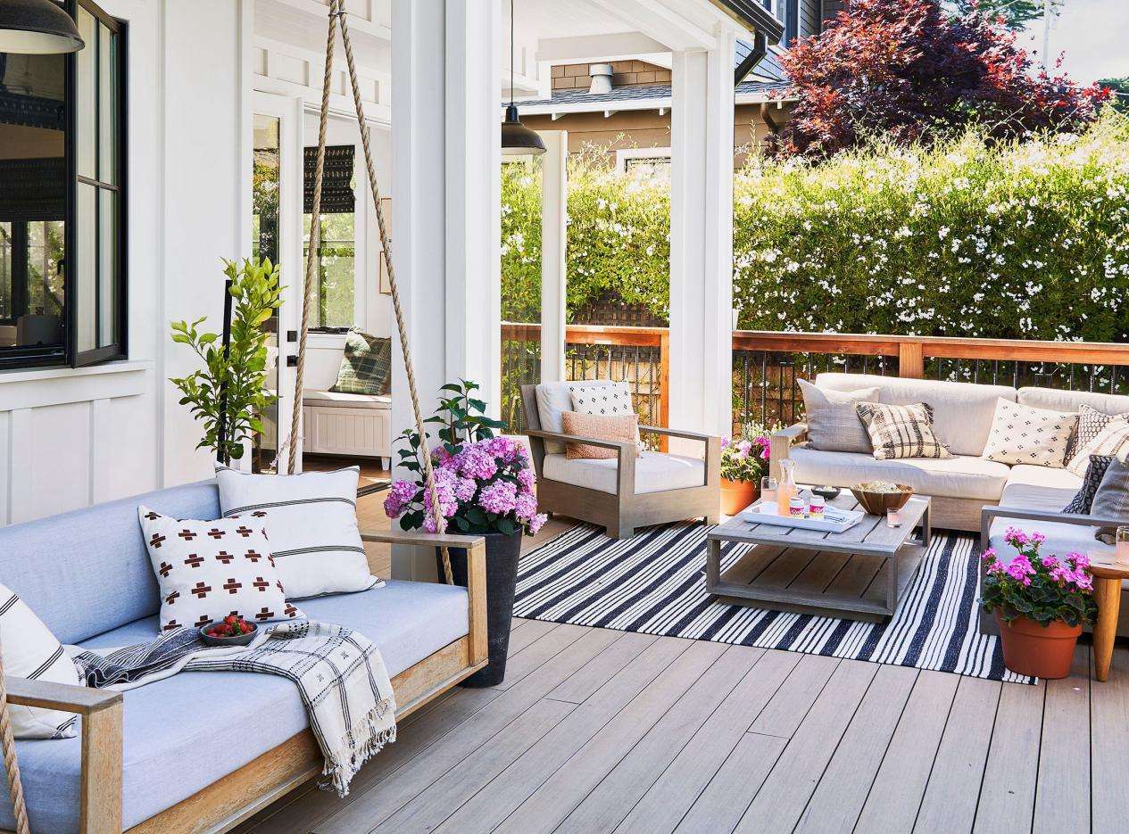 Spacious patio featuring a stylish black and white striped outdoor rug and comfortable seating.
